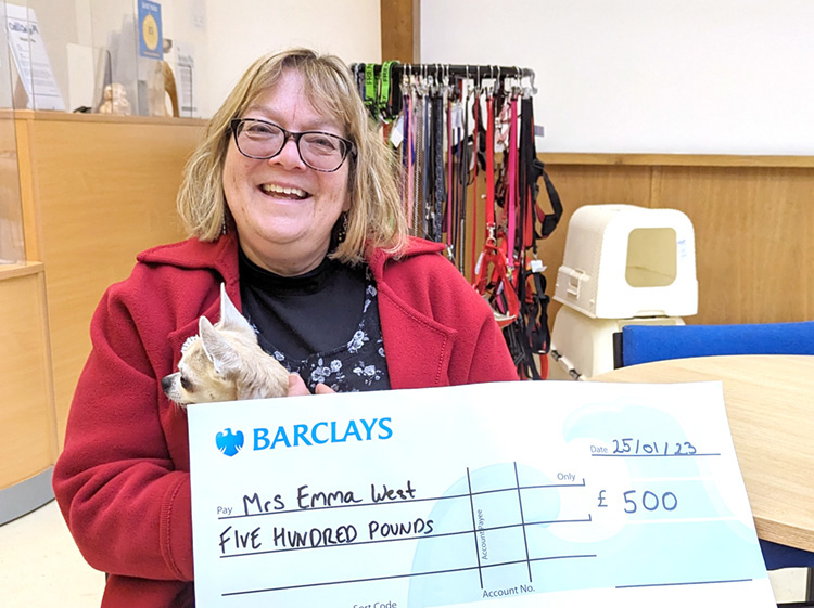 Woman collecting raffle prize with big cheque 