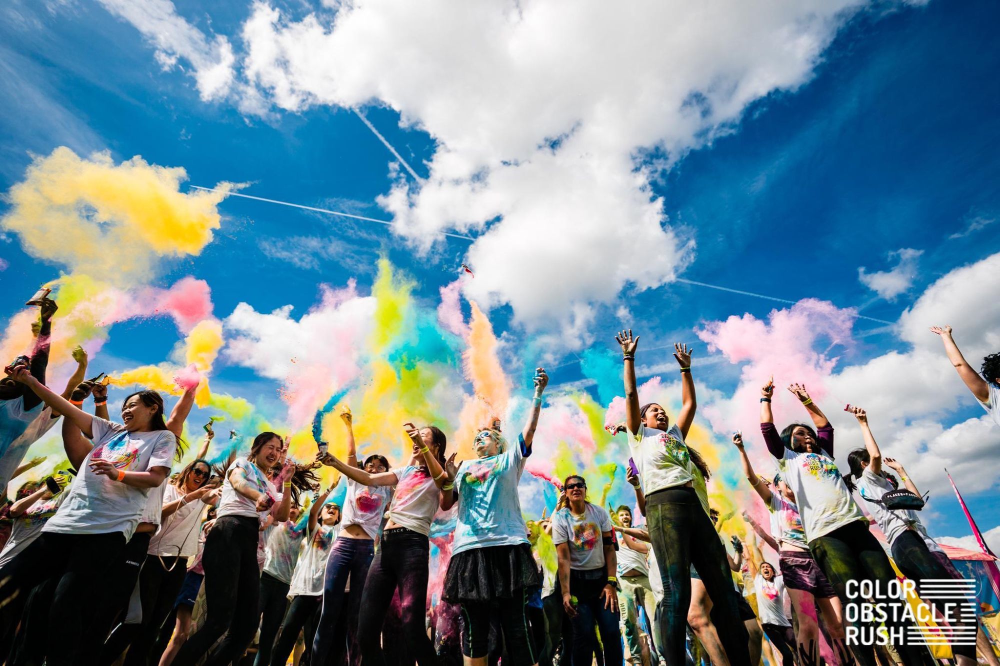 Group of people throwing ink powder at the Color Rush obstacle challenge event