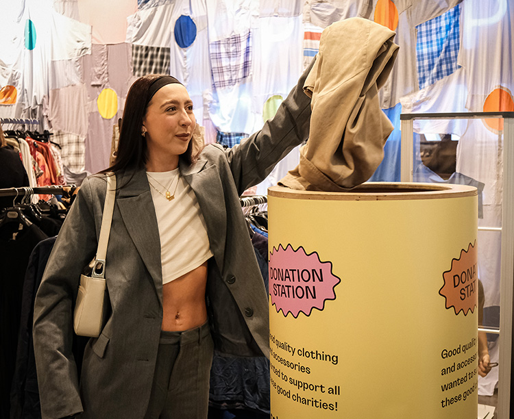 Young woman donating clothing to Charity Super Mkt store